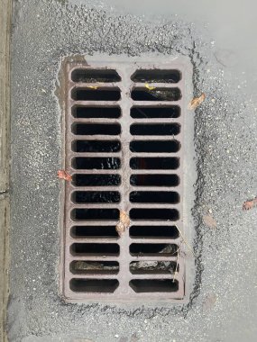 old rusty metal grate with a large hole