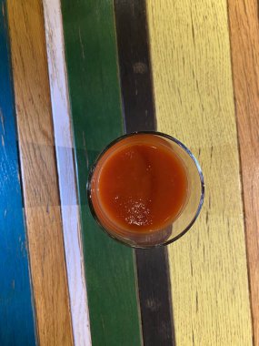a vertical shot of a wooden spoon with an orange juice