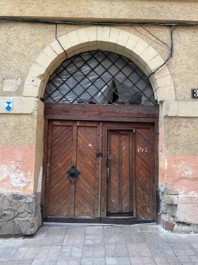 Penceresi olan tahta bir kapının dikey görüntüsü.