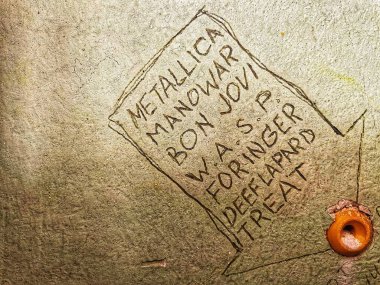 Bir demir metal tabelasının dikey yakın çekimi. Üzerinde 