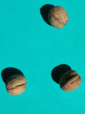 İki ceviz, bir bütün ve parlak sarı arka planda iki yarım. en üstteki görünüm.