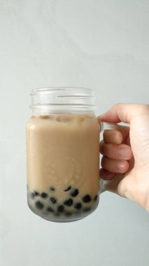 Beyaz arka planda cam bir fincanda buzlu kahve.