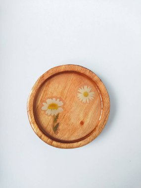 Beyaz arka planda çiçek desenli el yapımı reçine altlığı. Seçici odak.