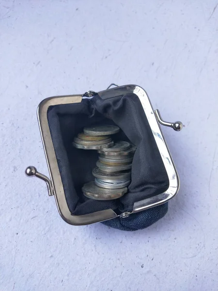 Coins in a purse on a white background, top view.