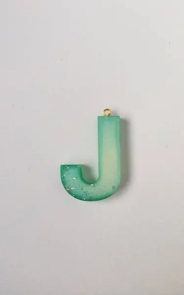 Beyaz arkaplanda reçineden yapılmış İngiliz alfabesinin J harfi