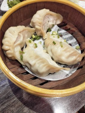 Tahta masada bambu sepetinde Çin buğulanmış hamur köftesi..