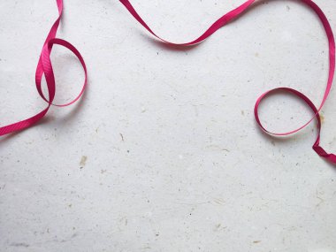 Metnin için kopyalama alanı olan eski kağıt arkaplanda pembe kurdele.