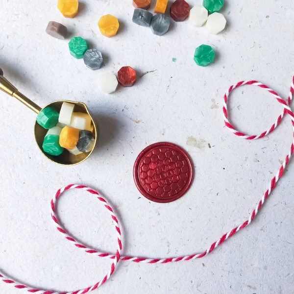 Kırmızı balmumu para ve beyaz zemin üzerinde renkli balmumu boncuk. en üstteki görünüm.