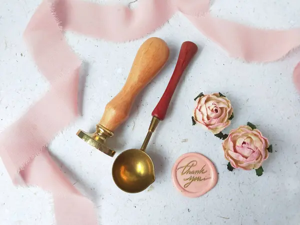 Wooden wax stamp set and colorful wax bead on white background, top view