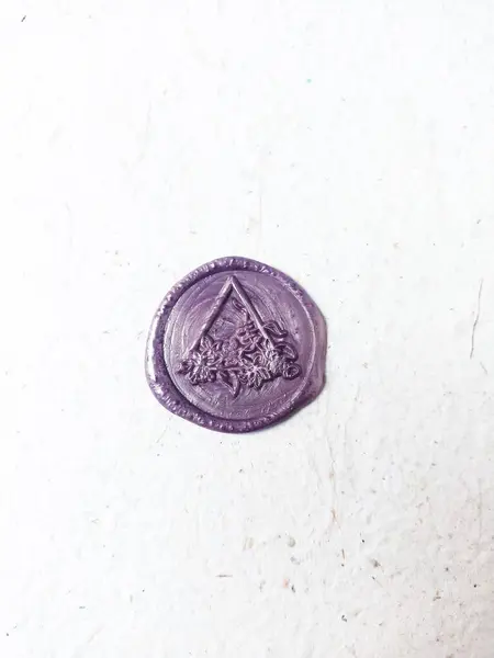 Bulanık arkaplanı olan mor ve beyaz bir bitcoin 'in yakın plan çekimi.