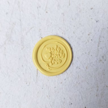 Beyaz bir yüzeyde sarı bir Çin sikkesine yakın plan.