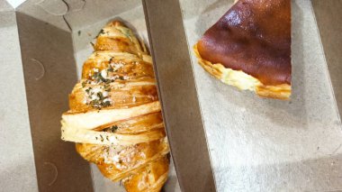 İçinde taze fırınlanmış cheesecake olan kahverengi bir kutu.