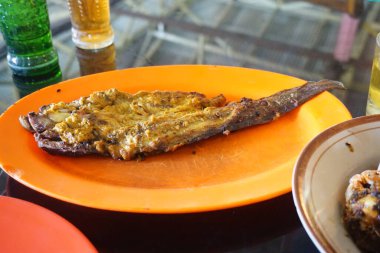 Soslu ve sebzeli kızarmış balık.