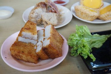 Geleneksel Çin Dim Sum 'u ahşap masada metal kasede. Masada bir sürü farklı yiyecek ve içecek var.