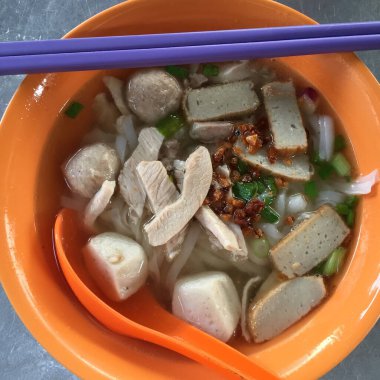 Lezzetli Asya yemeklerinin yakın görüntüsü. Bir kase yemek, kaşık ve yemek çubuğu..