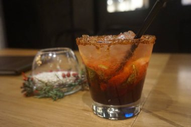 Bir dilim portakal ve bir dilim buzla bir bardak kokteyl.