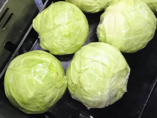 Markette sergilenen taze yeşil lahanalar. Naylon poşetlerde taze yeşil lahana, market tezgahında fotoğraf yakın plan.