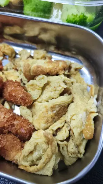 Kızarmış yiyecek ve çırpılmış yumurtaları metal bir tepside yakın plan çekimde. Lezzetli Asya yemeklerinin yakın görüntüsü