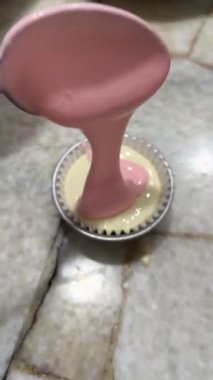a vertical shot of a cupcake with pink and white color