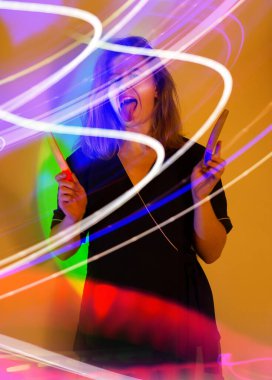 Nail manicurist photo content in neon light. Portrait of manicurist a holding manicure files in her hands.