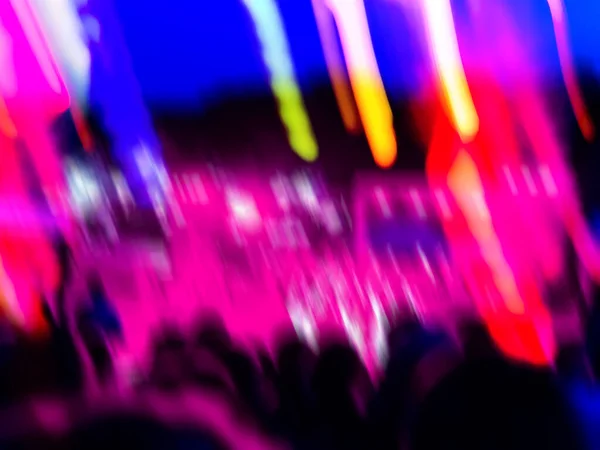 Blurred celebrating on summer open air. Dancing party and light show at music festival.