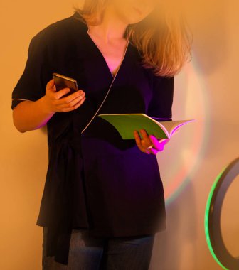 Kısa mesaj okumak için cep telefonu kullanıyor. Üniformalı blogcu, modern bir ofiste müşteri iletişimi kuruyor. Akıllı telefon kullanan nüfuzlu blogcu el.