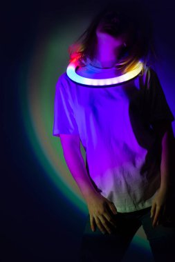 Sahnede, çok renkli arka planda neon ışıkta dans eden sarışın kadın model. Genç, güzel, zarif kız sahnede neon renginde dans ediyor.. 