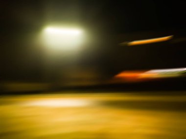 Geceleri bulanık şehir silueti ve çözülmüş binalar. Bulanık bir gecede modern şehirde hayat.. 