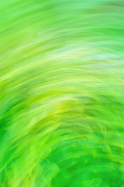 Green art blurred bokeh sparks flying background with motion effect. Green abstract flowing light trails effect. Green dynamic curving light trails.