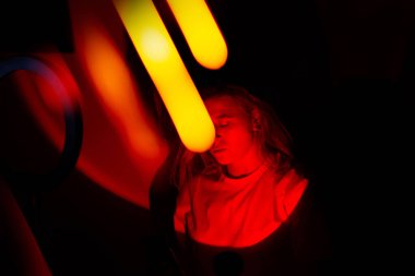 Neon parlak renkli stüdyo ışıkları ve Bokeh efektleri tatil portresinin yaratıcı organizatörü üzerinde. Tatil organizatörü ve neon renkli ışıkta hizmet sektöründe yönetici