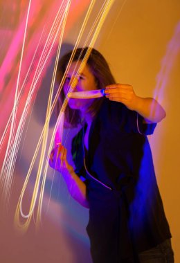 Müzik festivalinde dans eden enerjik genç kız. Neon tatil arka planında dans eden çekici güzel kız.