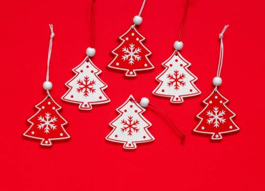 Kırmızı ve beyaz ahşap Noel oyuncakları kırmızı arka planda. Mutlu Noeller ve mutlu yıllar konsepti. Üst görünüm.