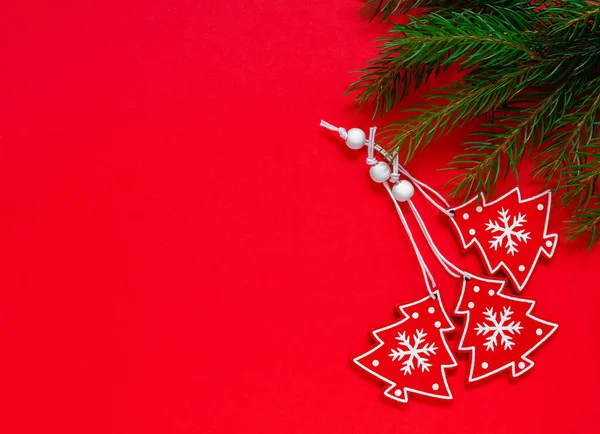 stock image Red wooden Christmas tree toys and fir tree branches on a red background. Top view. Copy space. Merry Christmas and Happy New Year concept.