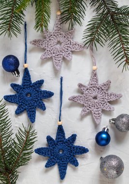 Gri mavi tığ işi el yapımı Noel ağacı oyuncakları ve köknar dalları. El yapımı Noel dekoru..