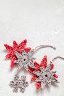 Beyaz arka planda gri, kırmızı tığ işi yıIbaşı ağacı oyuncakları. Uzayı kopyala El yapımı Noel dekoru..