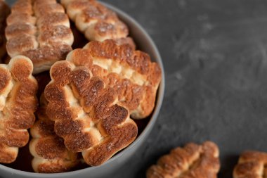 Ağaç şekilli tereyağlı kurabiyeler koyu gri arka planda bir kasede kapanıyor. Boşluğu kopyala.