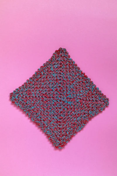 ピンクの背景に正方形のかぎ針編みの二重布 手作りのキッチンアクセサリー ストックフォト