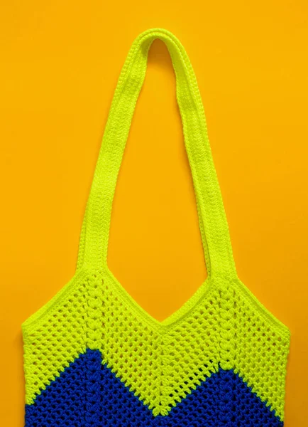 黄色の背景にブルーレモンのかぎ針編みのバッグ 波のパターンを持つかぎ針編みのネットバッグ 環境に優しいショッピングコンセプト トップ表示 — ストック写真