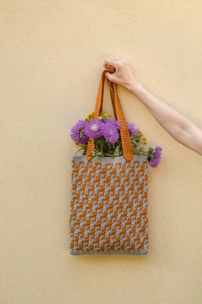 Kvinnas Hand Håller Virkad Väska Med Lila Blommor Gul Grå — Stockfoto