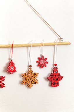 Noel duvarında orman sopası, ahşap kırmızı ve sarı Noel ağacı oyuncakları asılı. Alternatif, sürdürülebilir Noel. Boşluğu kopyala.