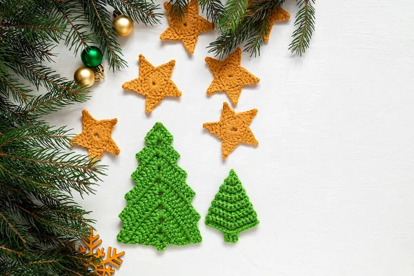 白い背景にお祭りのクリスマスの組成物 手作りのかぎ針編み緑のクリスマスツリーと黄色の星 スペースのコピー ロイヤリティフリーのストック画像
