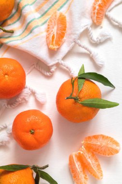 Beyaz arka planda yeşil yapraklı taze, sulu mandalinalar. Mandalina portakalı ya da mandalina. Soyulmuş mandalina. Sağlıklı beslenme. Çiğ yemek..