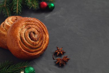 Noel tarçınlı çörekleri Noel süslemesi ve koyu gri arka planda yıldız anasonu ile yakın çekim yapın. Boşluğu kopyala.