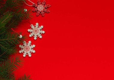 Kırmızı zemin üzerinde üç kırmızı beyaz kar tanesi. Noel İskandinav Dekoru. Noel ağacı oyuncakları. Boşluğu kopyala.