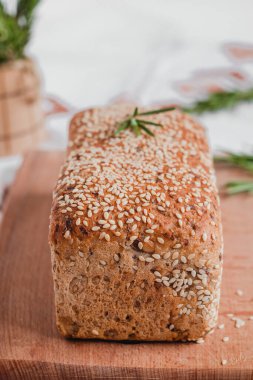 Tahtaya susam tohumları ve biberiye serpiştirilmiş taze ekmek. Sağlıklı ekmek..