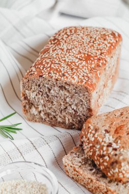 Biberiyeli açık masa örtüsü üzerinde susamlı dilimlenmiş ekmek..