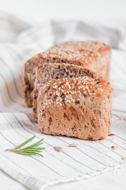 Biberiyeli açık masa örtüsünün üzerinde susam tohumlu tam tahıllı ekmek. Sağlıklı beslenme konsepti. Glütensiz ekmek..