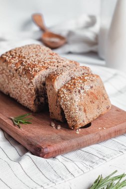 Susamlı ekmek ve sütle sağlıklı bir kahvaltı. Tahtada dilimlenmiş ekmek. Glütensiz ekmek..