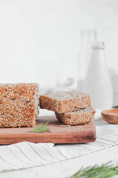 Taze susamlı ekmek ve sütle kahvaltı. Tahtada tam tahıllı ekmek. Glütensiz ekmek. Boşluğu kopyala.