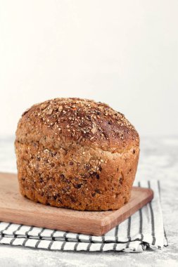 Ayçiçeği tohumlu tam tahıllı çavdar ekmeği ve beyaz arka planda tahta bir kesme tahtasının üzerinde keten. Boşluğu kopyala.